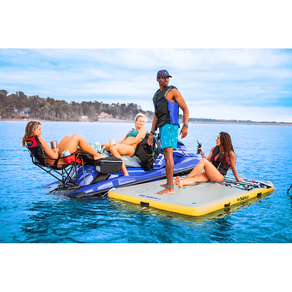 Solstice inflatable dock platform for lakes with woman doing yoga, floating water mat for sandbar, swimming, and paddleboarding, durable drop-stitch construction