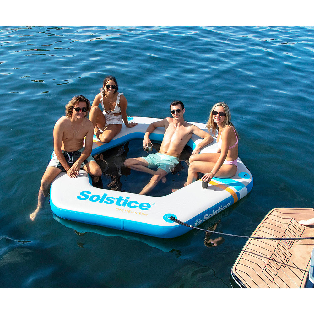“Group of friends relaxing on Solstice inflatable mesh dock with swim opening on a lake”